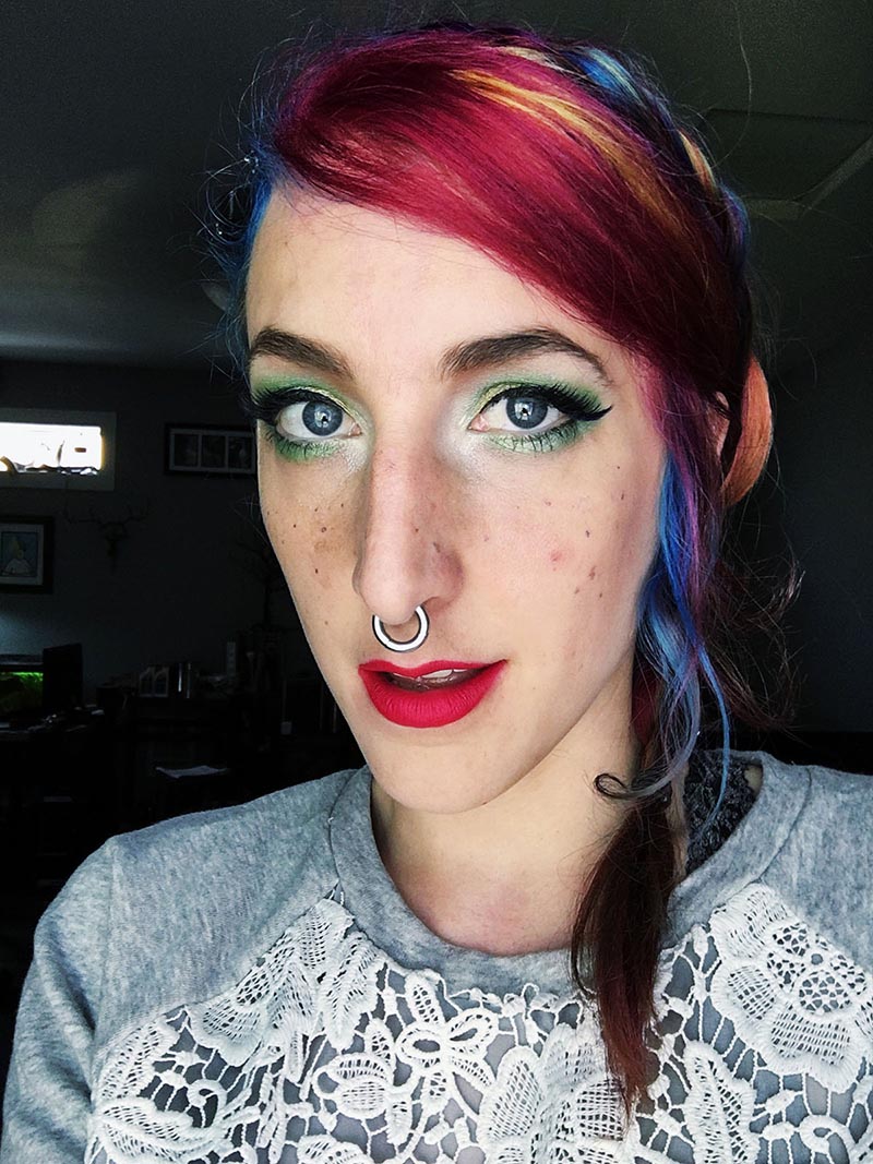 stephanie has rainbow hair and saturated green eye makeup, with hot pink lips