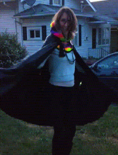 a knee length black sequin cape with rainbow led stripes running vertically down the back