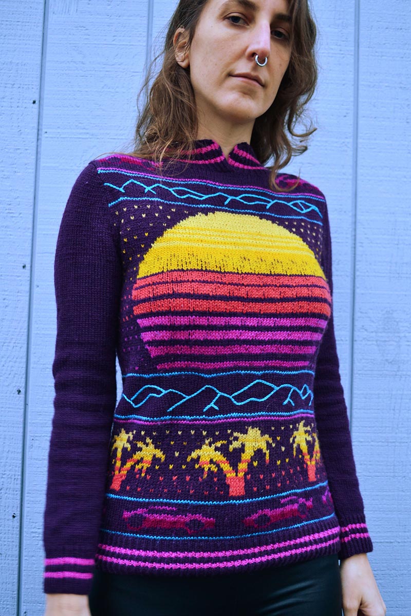 knit sweater with outrun motifs, including a setting sun, palm trees, and ferraris