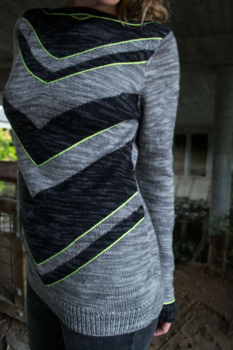 a long sweater featuring chevrons on the front and visible shaping on the back