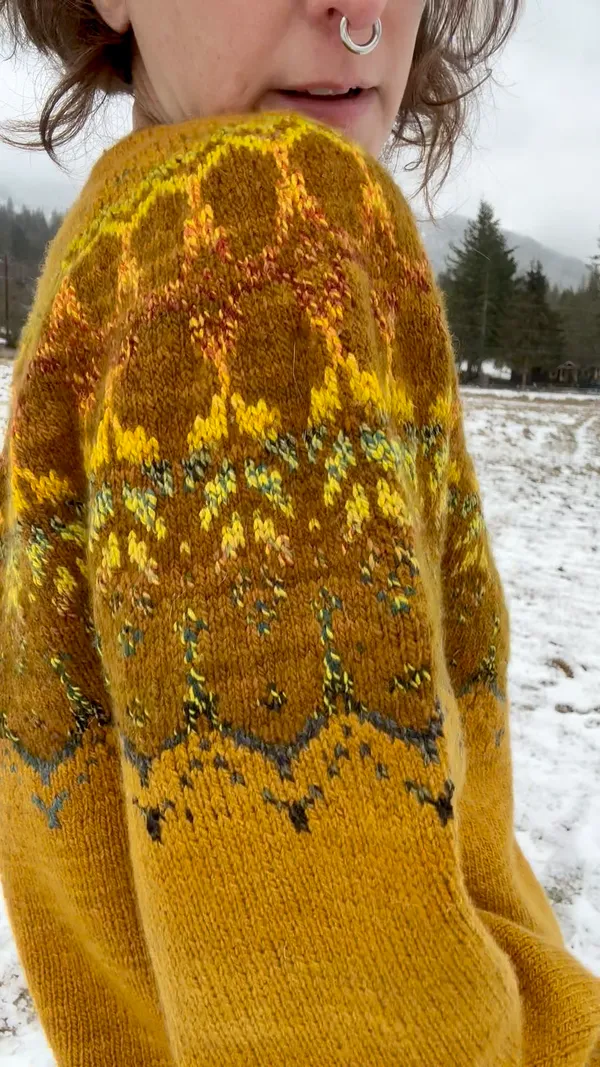 Sleeve detail showing variegation of leaf pattern against dark gold background