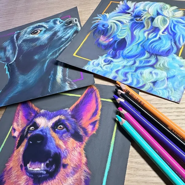All three portraits in a loose pile next to soft pastel pencils