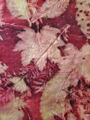 red fabric with cream colored leaf imprints